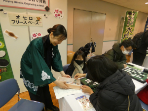 オセロブースで参加賞を配る様子